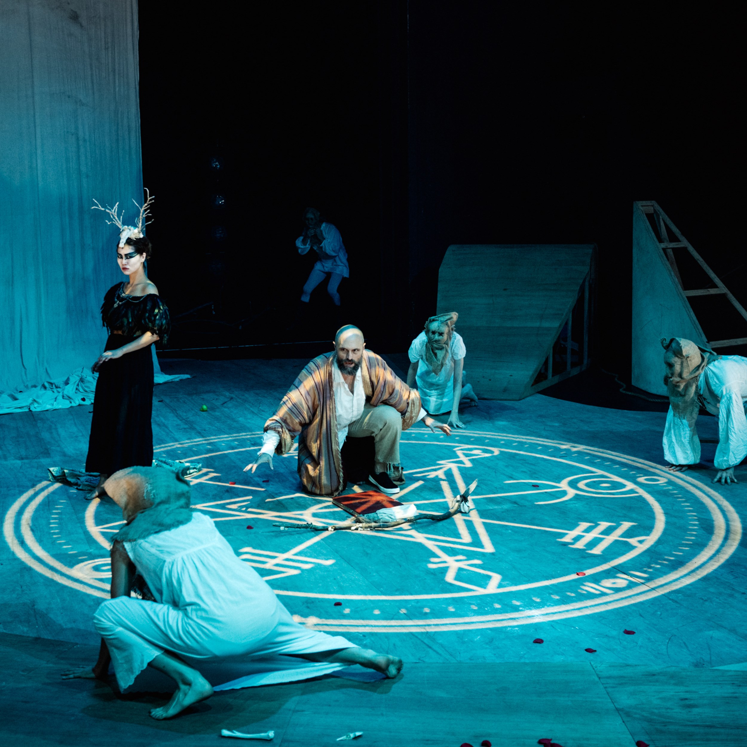 Promotional image of The Tempest/Hag-Seed Symposium for Seymour Centres Arts Education Program depicting a group of players gathered around a symbol projected onto the floor.