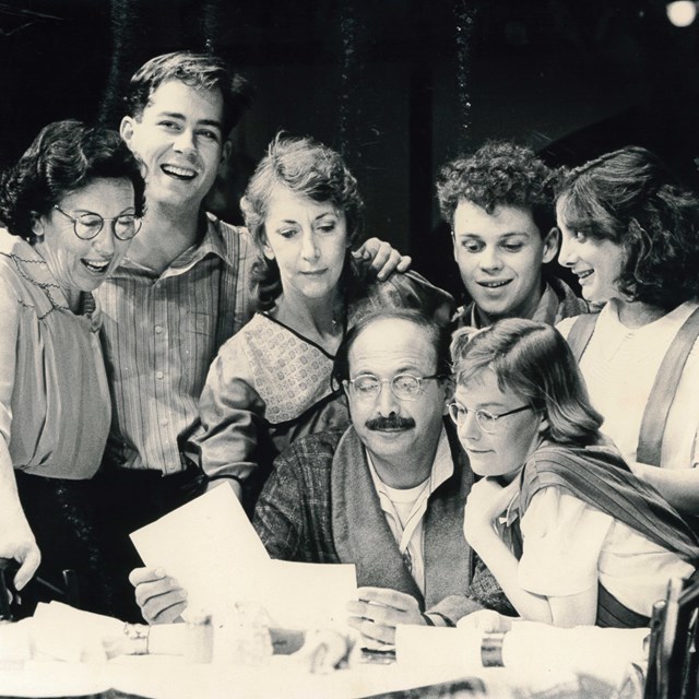 Black and white archival image of actors Jill Perryman, Tim Conigrave, Judi Farr, Miles Buchanan, Arna Hunter, Len Kaserman, and Cassandra Webb staring in Brighton Beach Memoirs in December 1985
